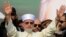 Muhammad Tahir-ul-Qadri waves to supporters on his arrival in Lahore on December 23.