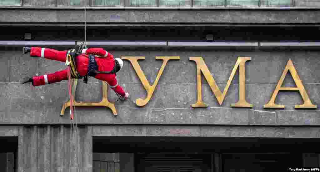 A worker cleans letters on the wall of the Russian State Duma, the lower house of parliament, in central Moscow on May 17. (AFP/Yury Kadobnov)