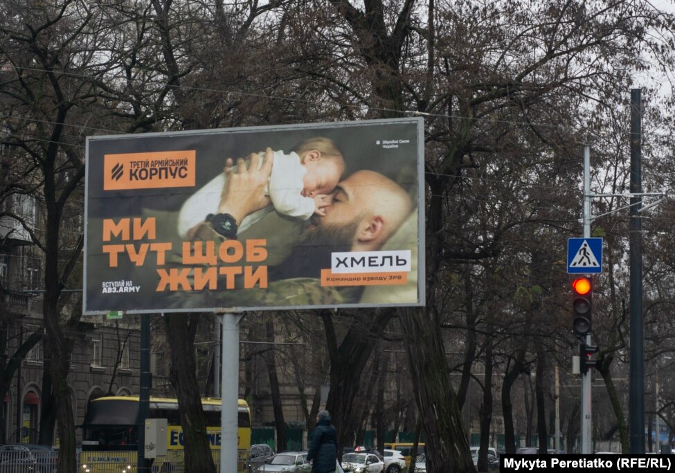 "We are here to live," reads a billboard promoting military service for Ukraine’s Third Army Corps in central Dnipro on December 11