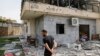 A man checks a house that was hit by a Hizballah rocket in Kiryat Shmona, near the Lebanese border in northern Israel, late last month. 