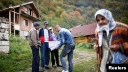 Bosnian Muslims speak with a census taker in the village Krusev Do, near Srebrenica on October 1