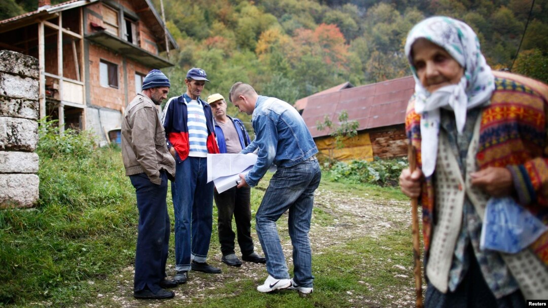 Bosnian Muslims speak with a survey taker during Bosnia's first census in the village Krusev Do, near Srebrenica, in October 2013.