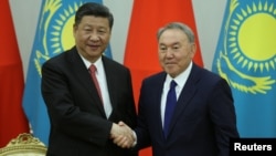 Kazakh President Nursultan Nazarbaev (right) and Chinese President Xi Jinping shake hands during a joint news conference following their meeting in Astana on June 8.