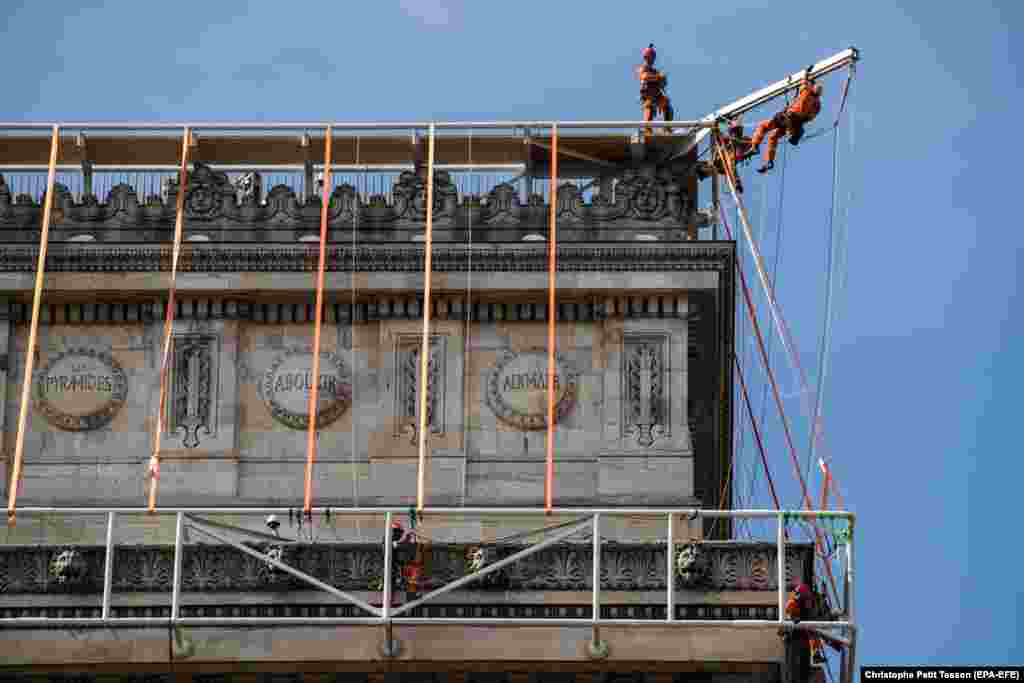 Workers install a framework around the arch. The team was given permission to drill into the stone of the Paris monument in some places. &nbsp;