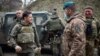 Ukrainian President Volodymyr Zelenskiy (left) visits the front line with Ukrainian troops in the Mariupol region on April 9. Zelenskiy's office said it had received no response to a request for dialogue.