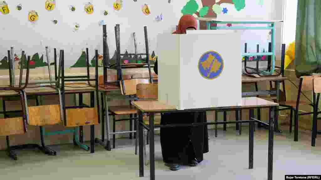 Një grua voton në një qendër votimi në Mitrovicën e Jugut në zgjedhjet e parakohshme parlamentare të Kosovës.
