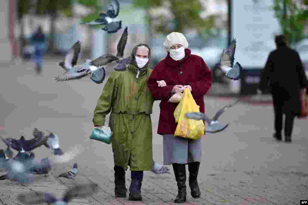 Two elderly women wearing face masks walk down a street in the town of Vitebsk, Belarus. (AFP/Sergei Gapon)