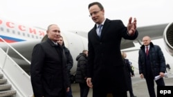 Russian President Vladimir Putin (left) is welcomed by Hungarian Foreign Minister Peter Szijjarto at the Liszt Ferenc International Airport in Budapest on February 2.