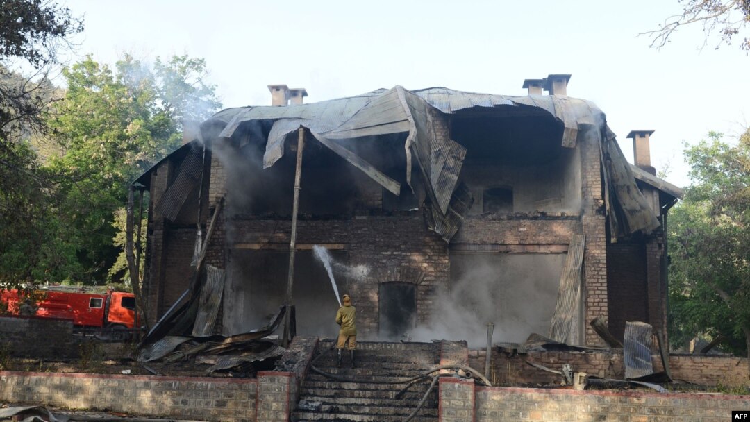 FILE: A Pakistani firefighter extinguishes a blaze which gutted a historical building in Balochistan's Ziarat region in 2013.
