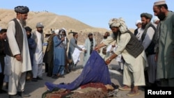 Oba ýaşaýjylary partlamada ölen cagalaryň jesetlerini ýygnaýar, 25-nji awgust, 2015. 