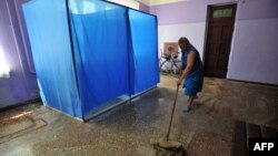 A woman mops the floor of a polling station ahead of the upcoming Ukrainian presidential election in the village of Oktyabr village in the Donetsk region on May 22. 