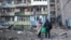 Residents stand by an apartment building in Kyiv that was damaged in a Russian missile strike on August 20.  