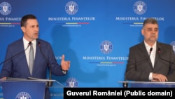 Premierul Marcel Ciolacu (d) și ministrul Finanțelor, Tanczos Barna (s).