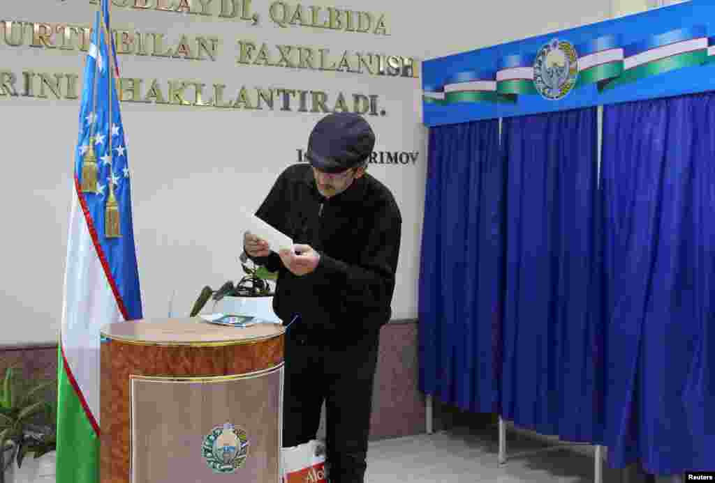 Uzbekistan -- A man studies his ballot during the presidential election in Tashkent, December 4, 2016