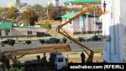 Ýaşaýyş jaýyny ak reňke boýaýan işgärler.