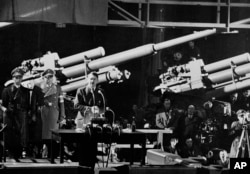 Adolf Hitler, în centrul imaginii, vorbește despre „situația din Europa” la o fabrică de muniții a concernului Rheinmetall dintr-o suburbie a Berlinului, la 10 decembrie 1940. În timpul războiului, compania și-a mutat sediul în capitala Reichului.