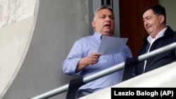 Orbán Viktor és Mészáros Lőrinc tárgyalnak egy felcsúti focimeccs alatt, a 2019-es európai parlamenti választások előtt, május 19-én. 