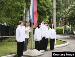 Elevi dintr-o școală din Moscova participă la o ceremonie de arborare a drapelului Federației Ruse.