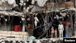 Palestinci stoje na spratu teško oštećene zgrade u gradu Gazi, Pojas Gaze, 2. novembra 2025.