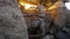A Ukrainian soldier fires a large-caliber machine gun while another prepares cartridges during combat against Russia-back separatists near Horlivka in the Donetsk region in late May.