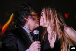 Хавьер Милей целуется с Фатимой Флорес на трибуне перед своими сторонниками в ночь объявления победных для него результатов второго тура выборов президента Аргентины. Буэнос-Айрес, 19 ноября 2023 года
