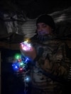 Военнослужащий 93-й ОМБр ВСУ «Холодный Яр» украшает гирляндой окоп на позиции возле Константиновки, 30 декабря 2025 года