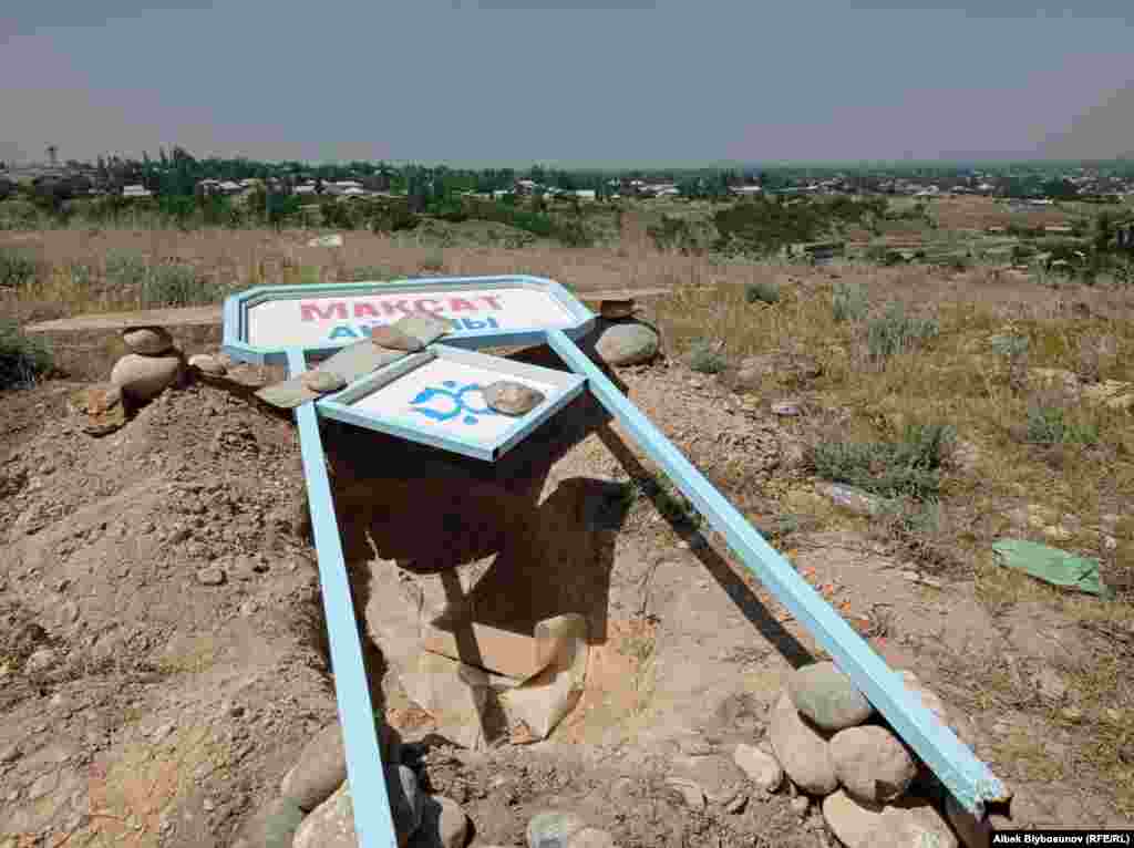 A sign on the outskirts of the village of Maksat in the Leilek region of Kyrgyzstan on May 2. Kyrgyzstan is observing two days of official mourning for 34 people who died in Batken Province. Kyrgyz officials reported that another 178 were injured and 50,000 people were evacuated from the area.