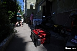 Oamenii trec pe lângă generatoarele portabile instalate din cauza întreruperilor de curent, în populara stațiune Gurzuf din Crimeea anexată, 31 iulie 2026