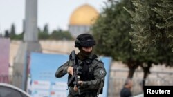 Një polic izraelit bën roje derisa palestinezët kryejnë faljen e xhumasë në Jerusalem, 20 tetor 2023.