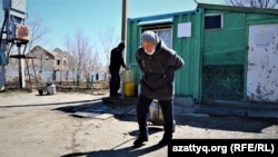Жительница села Приречное Гульзагифа Кишкенова тащит питьевую воду. Акмолинская область, 20 апреля 2021 года.
