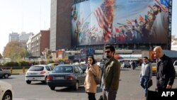 Iranian pedestrians cross a street at Valiasr square in Tehran, November 21, 2019