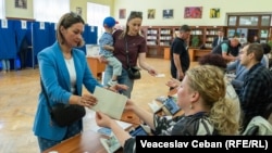 Alegători români din R. Moldova, votând, duminică, la secția de votare deschisă la Biblioteca Națională din Chișinău pentru alegerile prezidențiale românești, 4 mai 2025