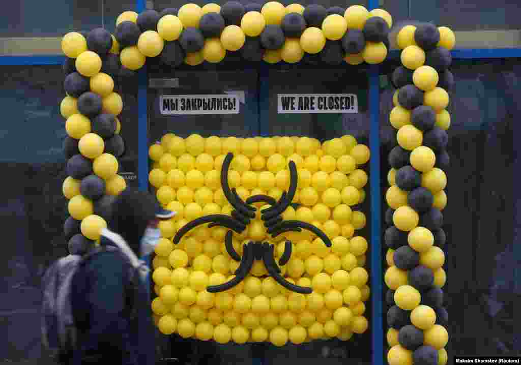 A pedestrian wearing a protective mask walks past a warning sign made of balloons outside a closed cafe, after Moscow authorities announced a partial lockdown and ordering residents to stay home to prevent the spread of coronavirus on March 30. (Reuters/Maksim Shemetov)