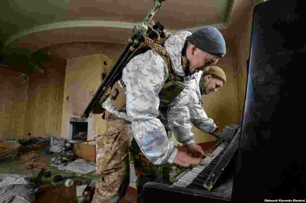 Ukrainian servicemen play the piano in а destroyed house near their position on the front line in the Donetsk region. (Reuters/Oleksandr Klymenko)