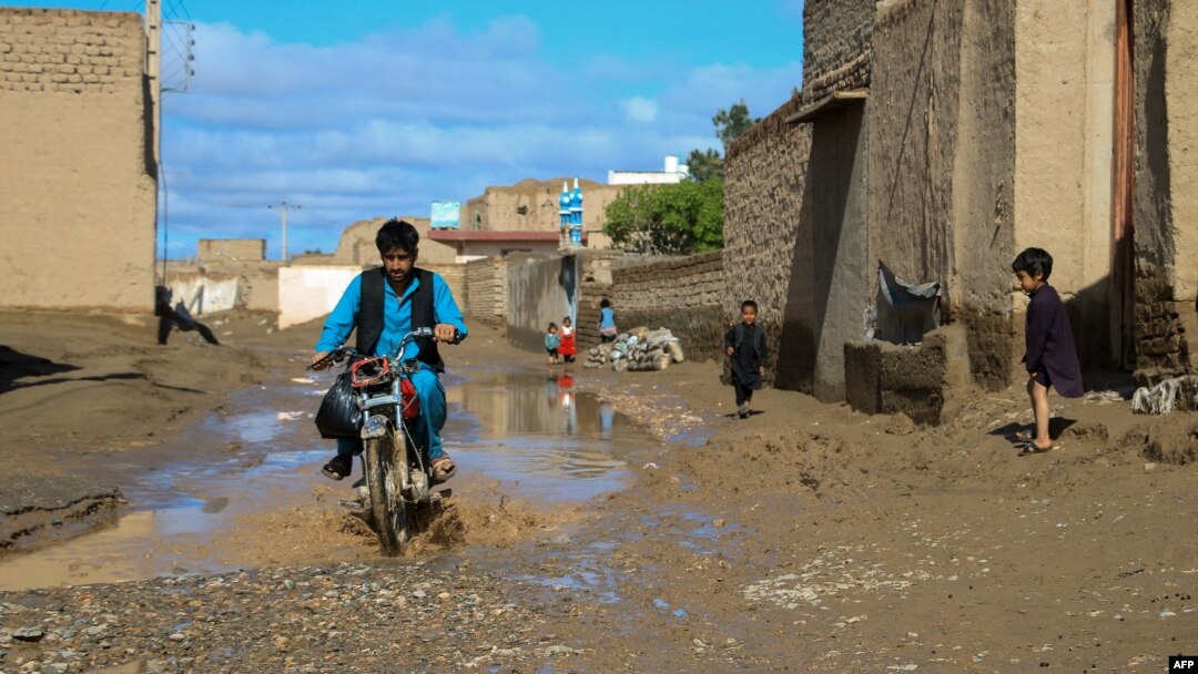 An Afghan motorcyclist drives through a sodden street following heavy rains and flash flooding in the Guzara district of Herat Province earlier this week.
