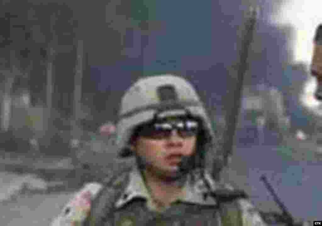 Iraq -- U.S. soldier, blast in background #rferl.org#