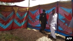 Pakistani police beside the grave of Sana Cheema before her exhumation on April 25