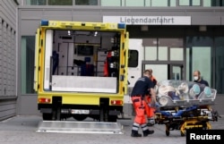 Paramedics load a patient believed to be Aleksei Navalny into an ambulance for transport to the Charite hospital in Berlin on August 22.