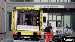 Doktorët fusin në një auto-ambulancë barelën që bartte Navalnyn. Berlin, 22 gusht, 2020. 