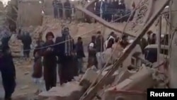 People gather near rubble in the aftermath of Pakistan's military strike on an Iranian village in Sistan-Baluchistan Province on January 18. (screen grab)