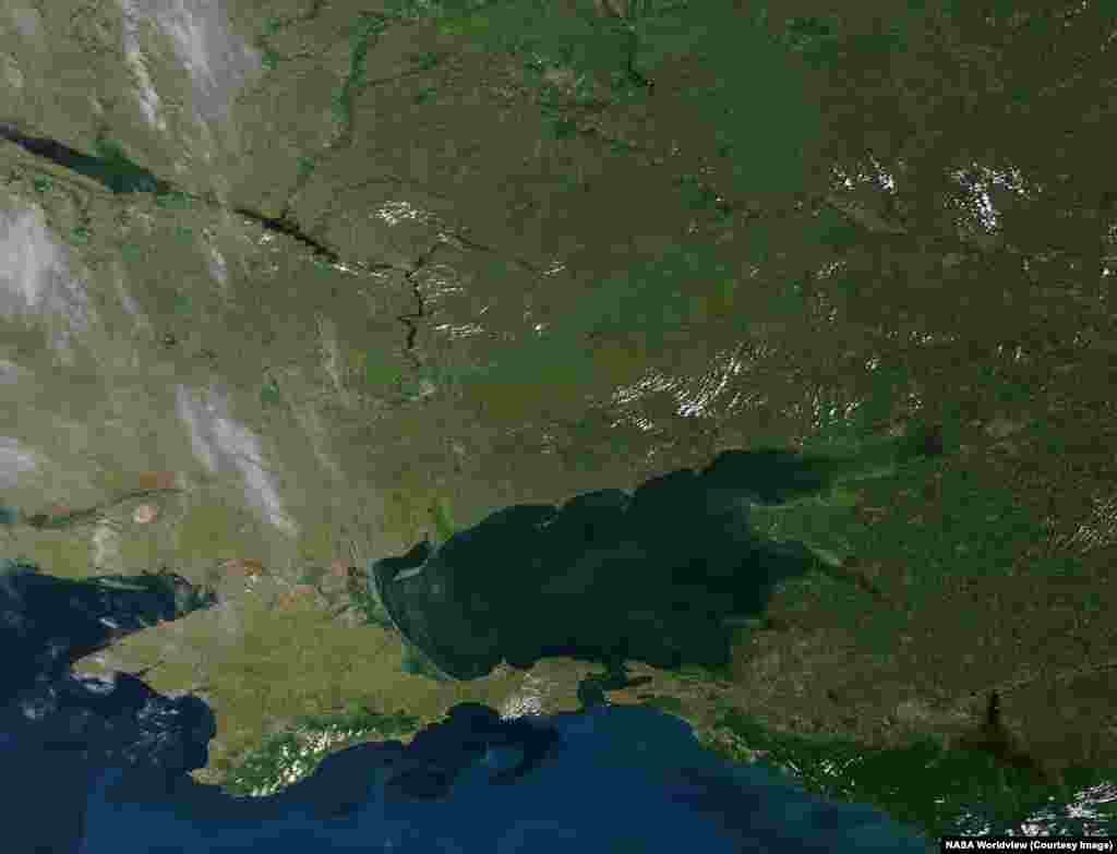By day, NASA satellites have captured other momentous effects of Russia's ongoing war on Ukraine.These images of southeastern Ukraine and western Russia that were made on June 14, 2012 and June 6, 2026 highlight the disappearance of the water reservoir (center left) that stretched northeast of the Kakhovka Dam on Ukraine's Dnieper River.The dam was destroyed on June 6, 2023 and its reservoir drained into the Black Sea. The 2026 photo also shows a band of green and untended land sweeping from the center of the image up to its top right, where the war's current front line stretches.