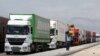 A man walks beside trucks waiting to cross into Iran from the Turkish side of the border near the Gurbulak border crossing between Turkey and Iran on June 27, 2012, at Dogubeyazit.