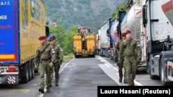 Полските војници, дел од мировната мисија на Косово, КФОР, минуваат низ барикади во близина на граничниот премин Јариње меѓу Косово и Србија, 28 септември 2021 година.