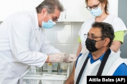 A doctor administers the first dose of Chinaese Sinopharm coronavirus vaccine to a patient at his office in Kallosemjen on March 25.