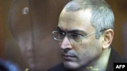 Former Yukos chief Mikhail Khodorkovsky stands behind a glass wall in a courtroom in Moscow during a hearing in 2010.