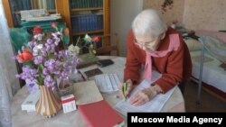 An elderly woman casts her vote from home in Moscow's municipal elections on September 10. 