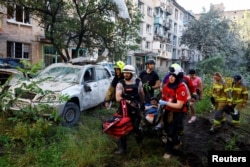 Рятувальники виносять поранених. Київ. Ранок 2 липня 2026 року. Наслідки масованої російської атаки по Києву
