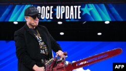 Elon Musk ține o drujbă pe care scrie „Trăiască libertatea, la naiba” în timpul Conferinței anuale de acțiune politică conservatoare (CPAC. 20 februarie 2025.