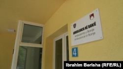 Tabela e sapovendosur në ndërtesën e ambulancës në fshatin Banjë të Skenderajt, tregon emrin e saj në tri gjuhë: shqip, serbisht dhe anglisht, 15 prill 2026.