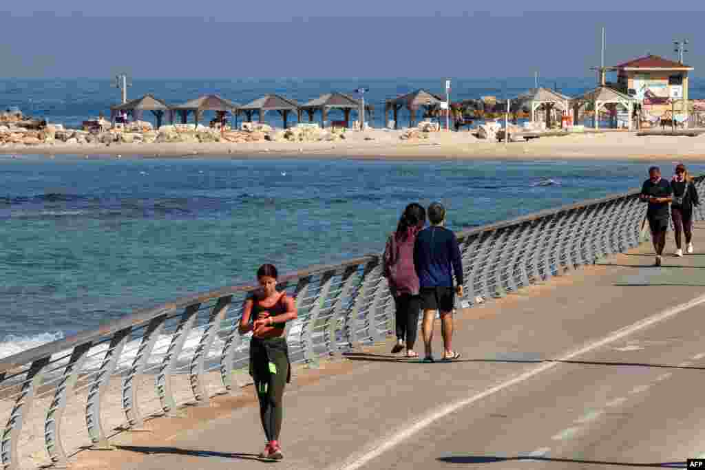 Oamenii se plimbă pe malul mării în Tel Aviv, pe 3 martie 2026. Temperatura maximă a aerului marți era de 18 grade, cu cer în general însorit.